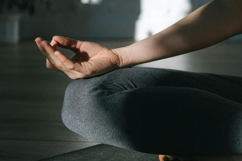 Close up of hands on knee during hotpod yoga norwich