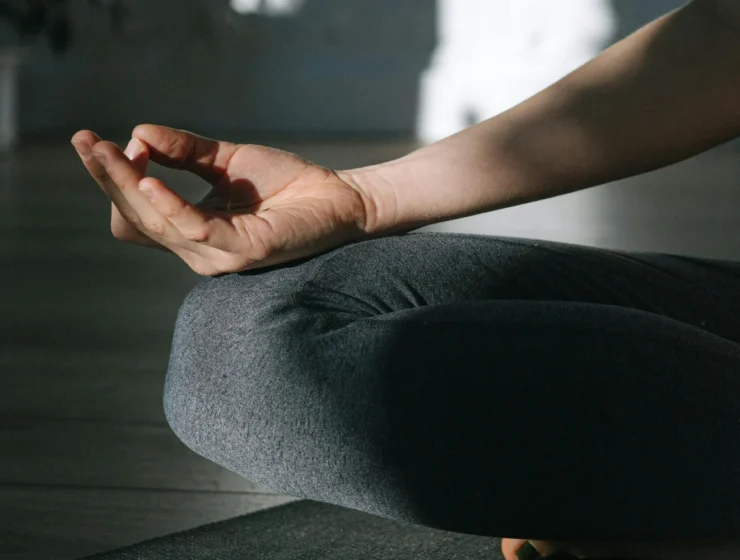 Close up of hands on knee during hotpod yoga norwich