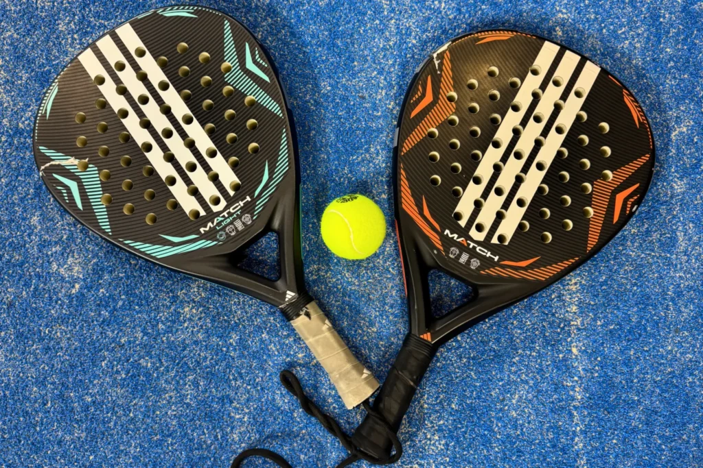 Padel rackets and a ball on the ground