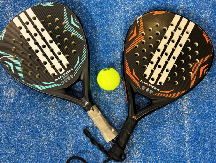 Padel rackets and a ball on the ground