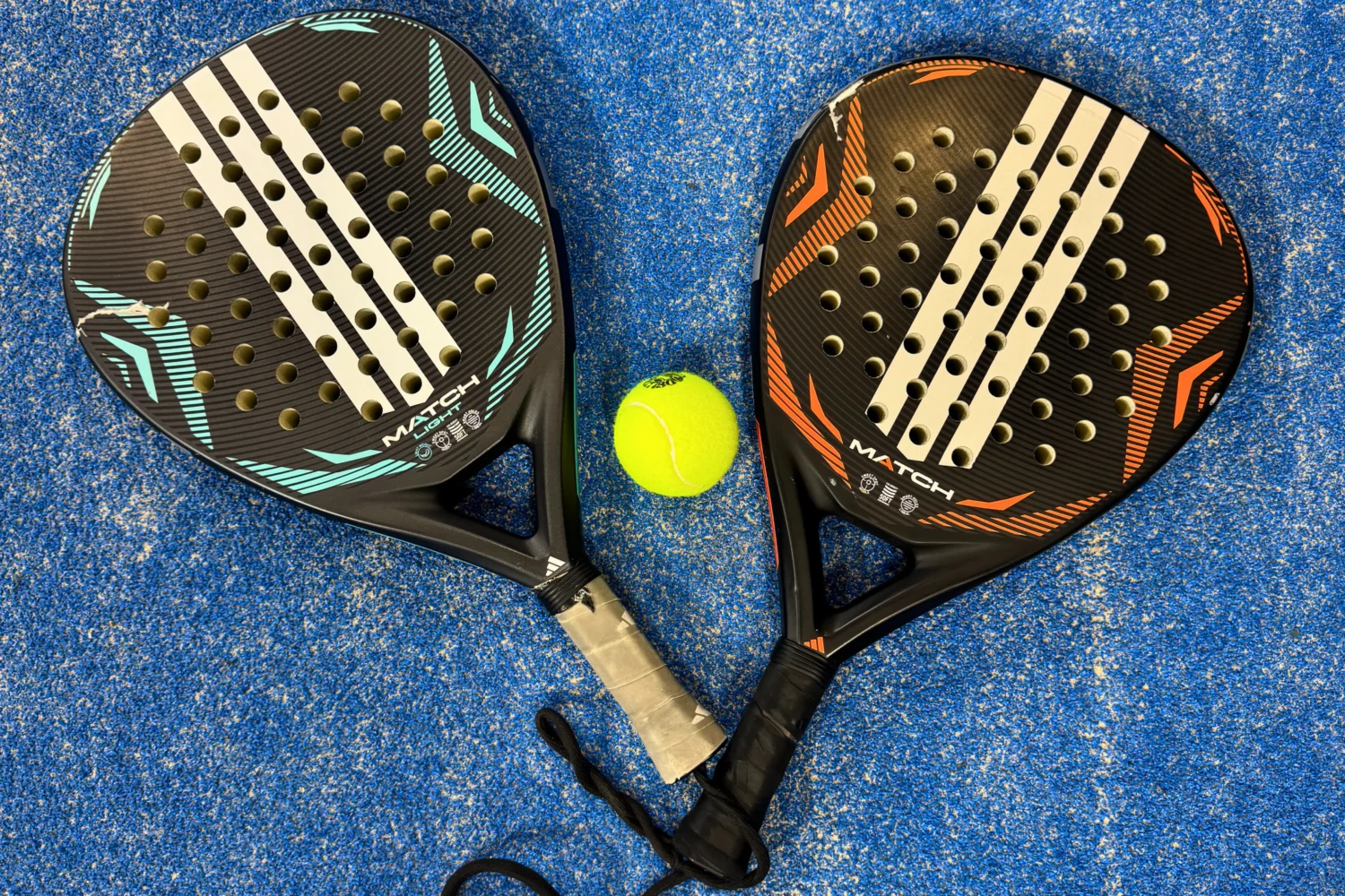 Padel rackets and a ball on the ground